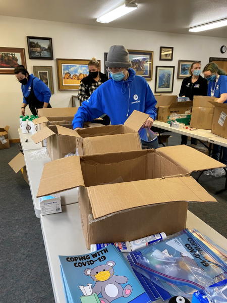 Juneau Americorps members stuffing emergency response items into bags